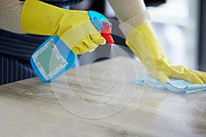 Hands, gloves and spray cleaning table with disinfectant for clean house. Kitchen counter, home safety and disinfection