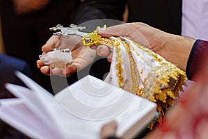 hands in gold lace and white shawl with open bible