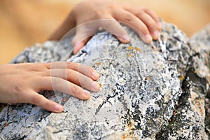 Hands grabbing/climbing mountain rock