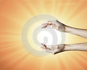 Hands grabbing the sun between, holding a dream, spark of hope, the light of faith background