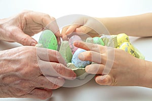 Hands of grandson and grandmother make crafts from Easter eggs. Easter concept and family traditions and pastime