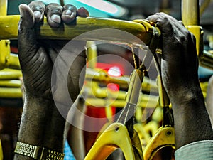 Hands grasping handrail on crowded Indian bus,Mysuru,Karnataka,India