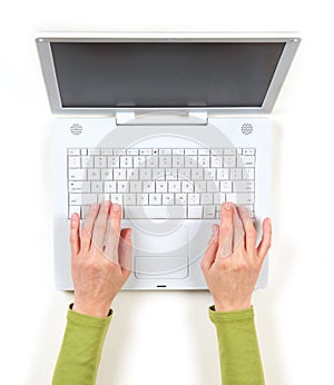 Hands in green jacket and white laptop