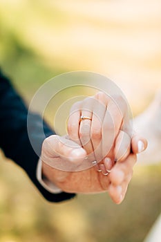 Hands of groom and bride hold together