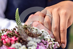Hands groom and bride with wedding rings and flowers bouquet celebration love symbol