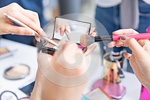 Hands of group girls holding makeup brush and palette for makeup