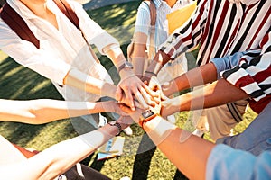 Hands of groupmates lying one on another.