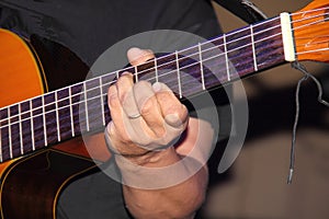 The hands of the guitarist make the strings of the instrument vibrate photo