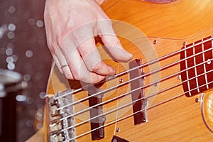 Hands of the guitarist`s bass