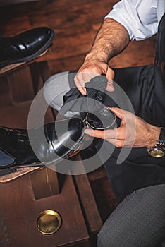 Hands of a guy polishing the shoes