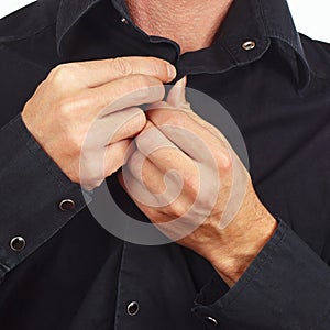 Hands a guy unbutton his black shirt closeup photo