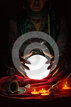 Hands from gypsy fortune teller above magic crystal ball