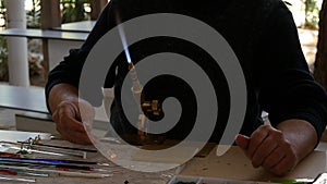 Hands of the handicrafts man making a glass object crafts.