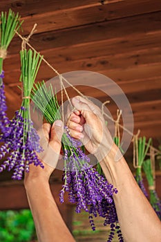 Hands hanging bunch of lavender flowers on string