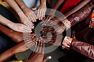 Hands of happy group of multinational African, latin american and european people which stay together in circle