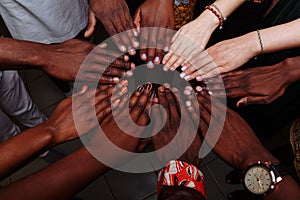 Hands of happy group of multinational African, latin american and european people which stay together in circle