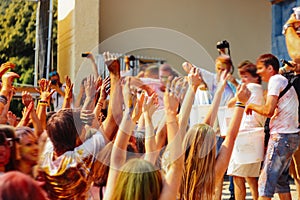 Hands of happy people crowd having fun at stage at holi fest, fe