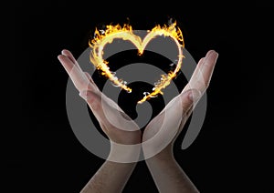 hands with heart fire icon over. Black background