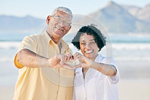 Hands, heart and a senior couple on the beach together during summer for love, romance or weekend getaway. Portrait