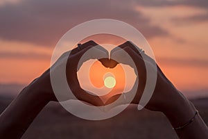 Hands heart at sunset