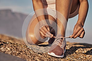 Hands, hiking and tie shoes in nature to start running, workout or training. Sports, wellness and female or woman tying