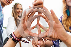 Hands of hippie friends showing peace sign