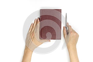 Hands hold blank red hardcover book on white background