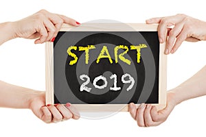 Hands hold chalkboard for the new year 2019 - isolated on white background