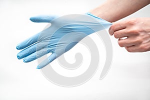 Hands hold a disposable protective mask on a white background