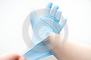 Hands hold a disposable protective mask on a white background