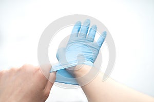 Hands hold a disposable protective mask on a white background