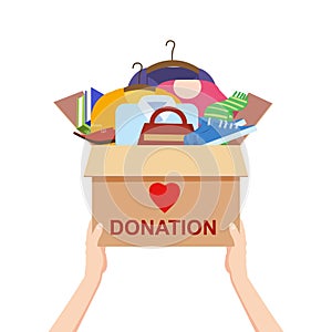 Hands hold a donation box with clothes, books, shoes. help for refugees, poor kids. Awareness and charity concept