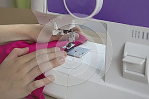 Hands hold the fabric. sewing machine sewing thread