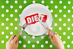 Hands hold flatware above dieting plate, Top View