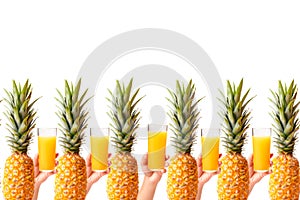 Hands hold glasses of fresh pineapple juice near ripe pineapple against white background