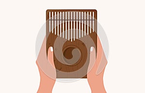 Hands hold kalimba. Mbira or thumb piano. African traditional musical instrument. Folk wooden mbira with carvings 
