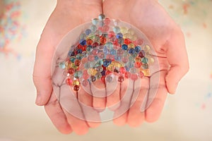 Hands hold numerous colorful transparent balls, photo