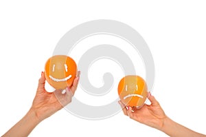 Hands hold oranges with smile and insult photo