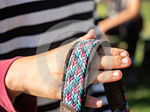 Hands hold strip of horse bridle, part of classic halte