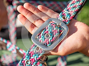 Hands hold strip of horse bridle, part of classic halte