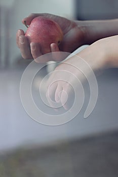 Hands holding apple with window reflection