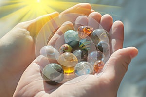 hands holding assorted marbles against a bright backdrop