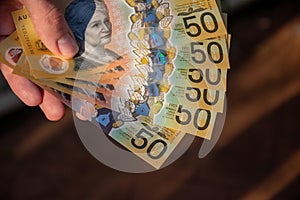 Hands holding australian dollars 50 banknotes to make a payment