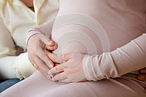 Hands holding belly of a pregnant woman