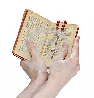 Hands holding the Bible and praying with a rosary