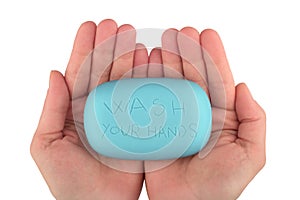 Hands holding blue soap bar with wash your hands written