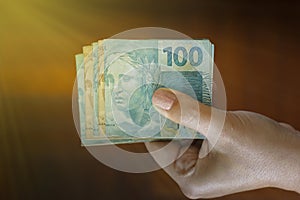 Hands holding Brazilian real notes - Money from Brazil