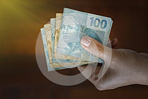 Hands holding Brazilian real notes - Money from Brazil - Notes of Real - Brazil BRL banknote