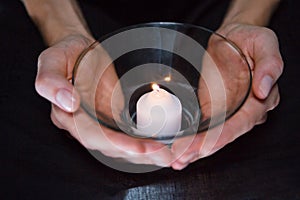 Hands holding candle