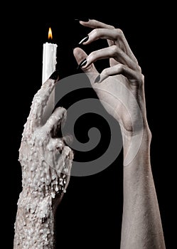 Hands holding a candle, a candle is lit, black background, solitude, warmth, in the dark, Hands death, hands witch